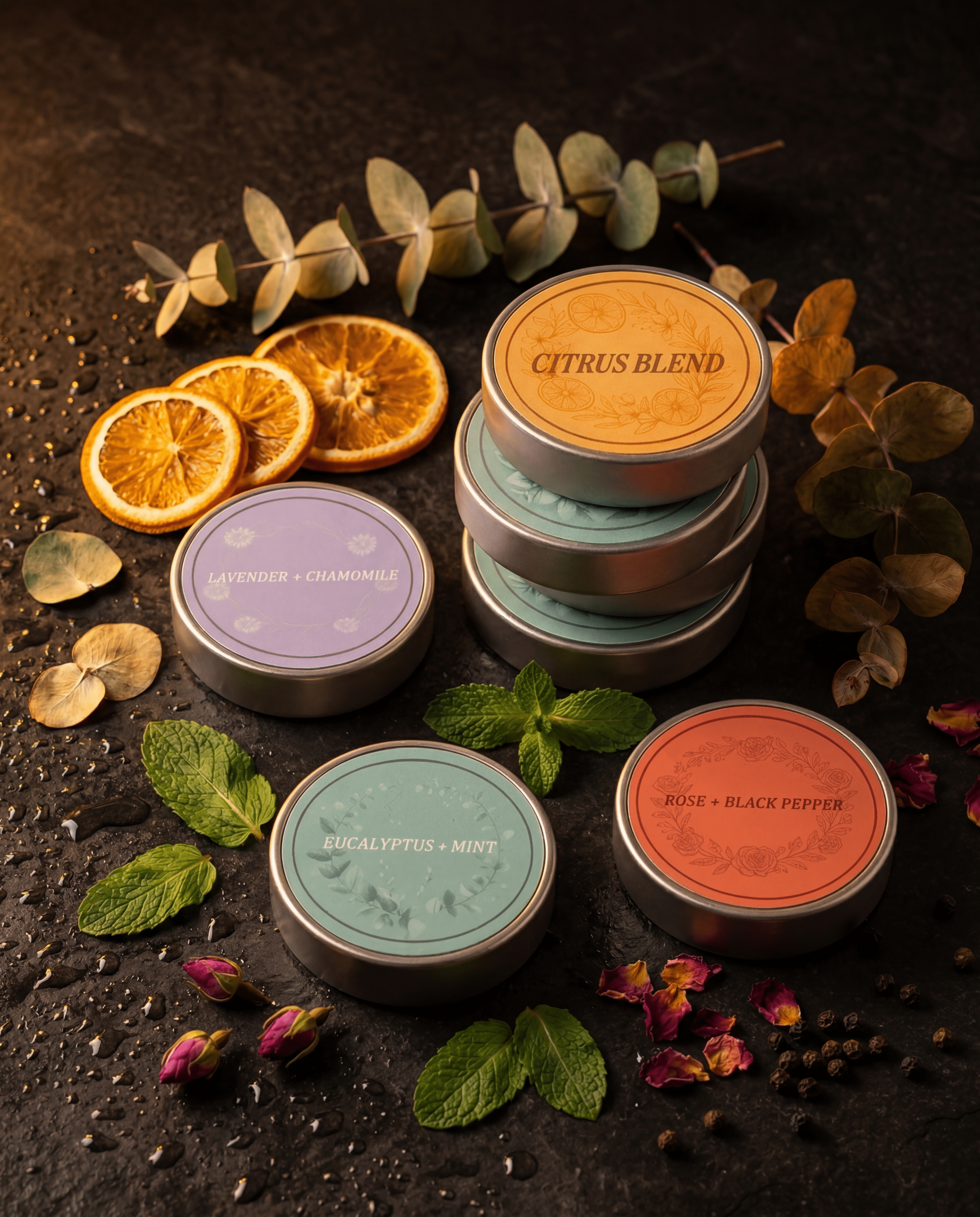 All four Ritual Cubes scent tins arranged together on dark surface with mixed botanicals