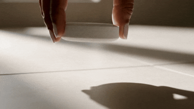 Fingers placing a Ritual Cube on the shower floor