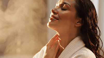 Woman in steam with eyes closed, breathing deeply — the exhale moment